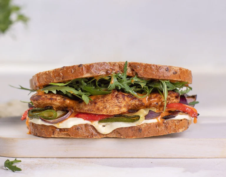 A grilled chicken and Mediterranean vegetable sandwich on a multi seed sourdough bread with Italian Dressing and Real Mayonnaise.